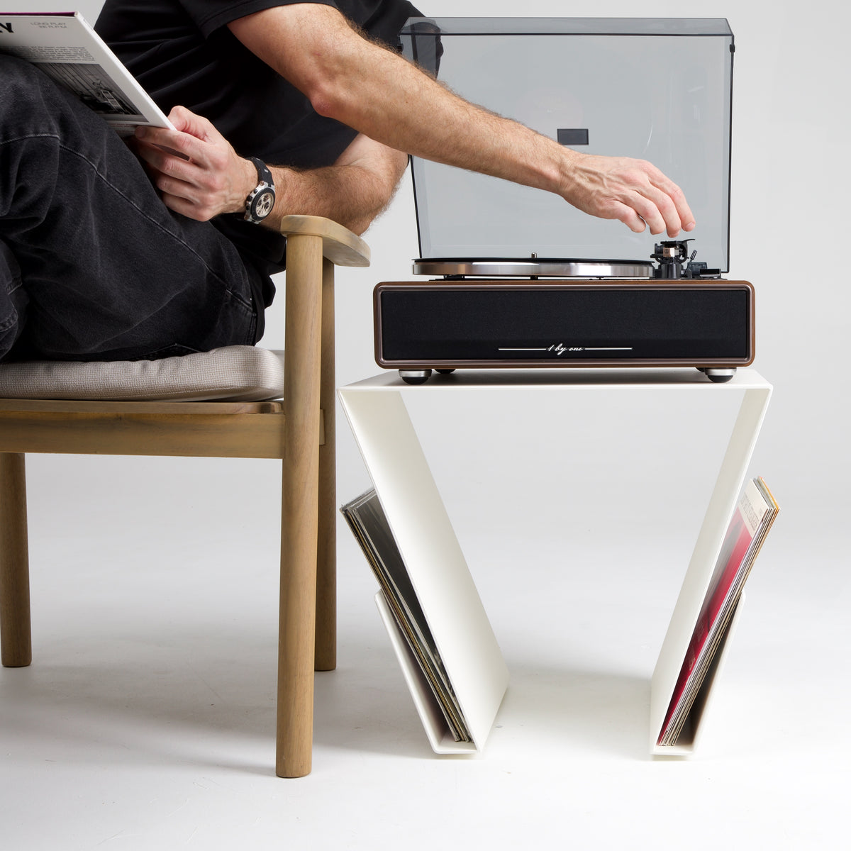 Mesa auxiliar Yesa con tocadiscos en la parte superior con una persona poniendo un vinilo y vinilos en los laterales