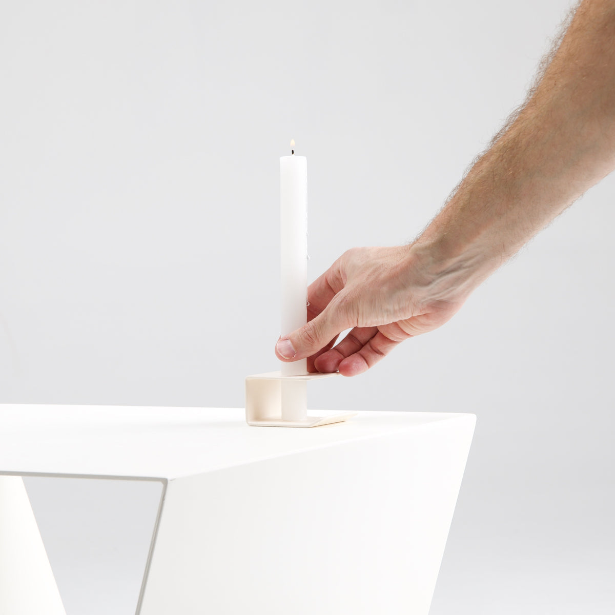 Soporte multifuncional Sellent sujetando una vela sobre la mesa auxiliar Yesa