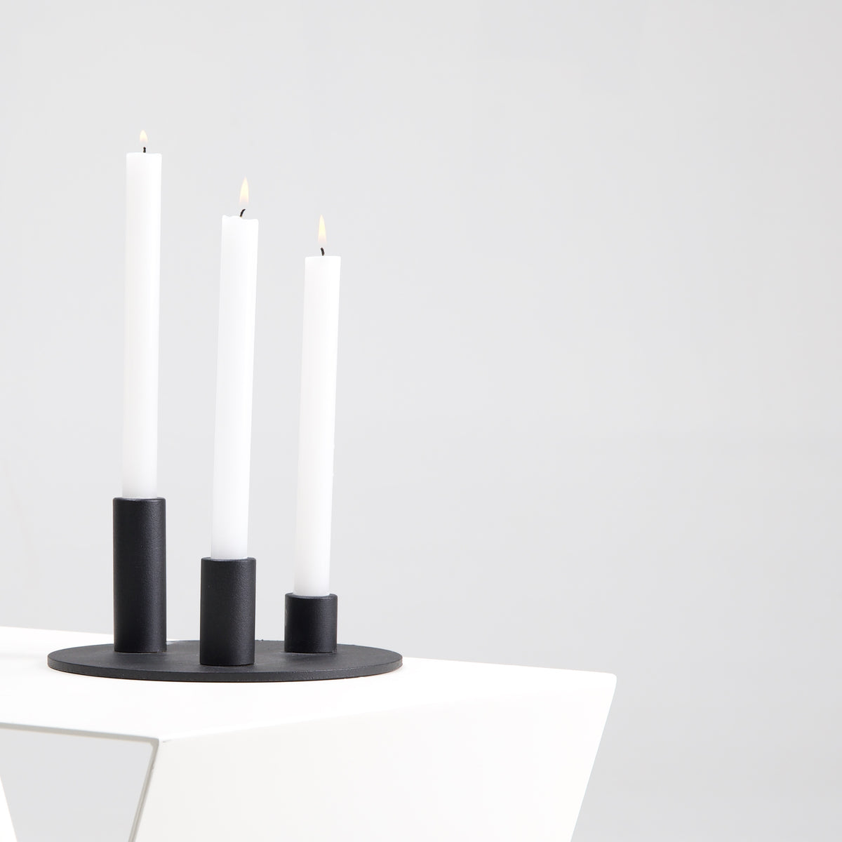 Soporte de velas Famorca con velas encendidas sobre mesa auxiliar Yesa de cerca