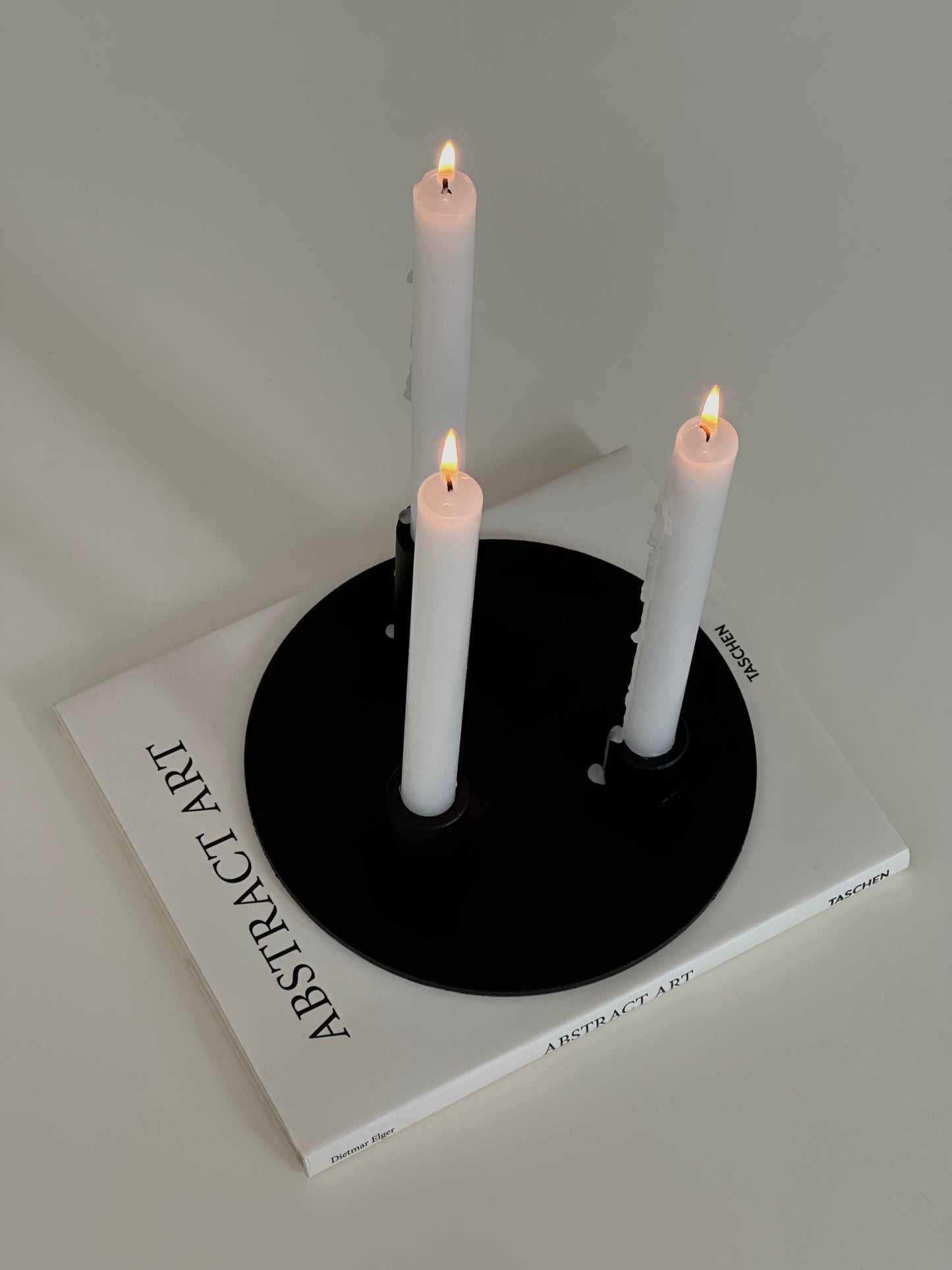 Soporte velas Famorca con velas encendidas sobre un libro