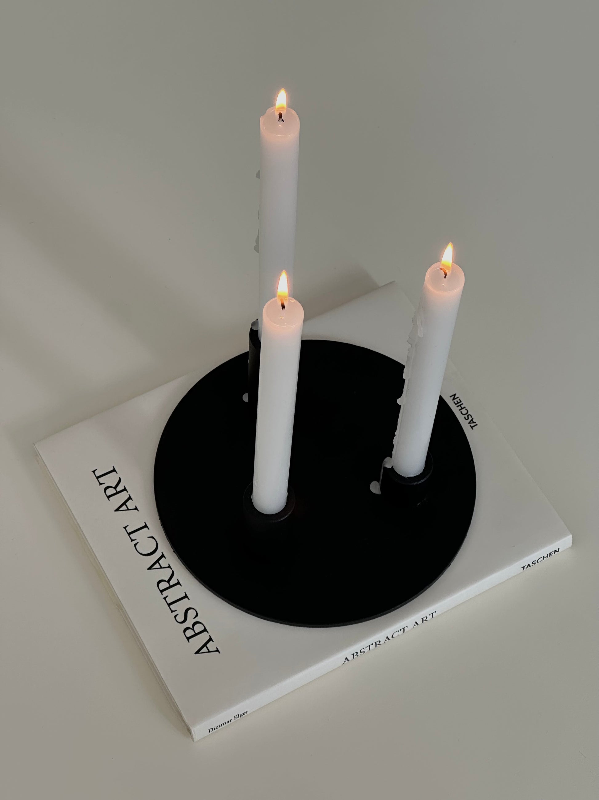 Soporte velas Famorca con velas encendidas sobre un libro