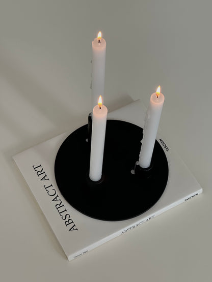 Soporte velas Famorca con velas encendidas sobre un libro